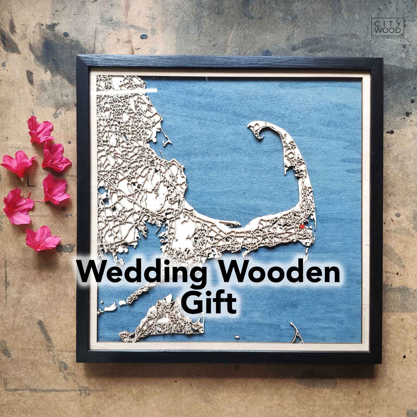 Framed wooden map of Cape Cod on blue background, pink flowers.